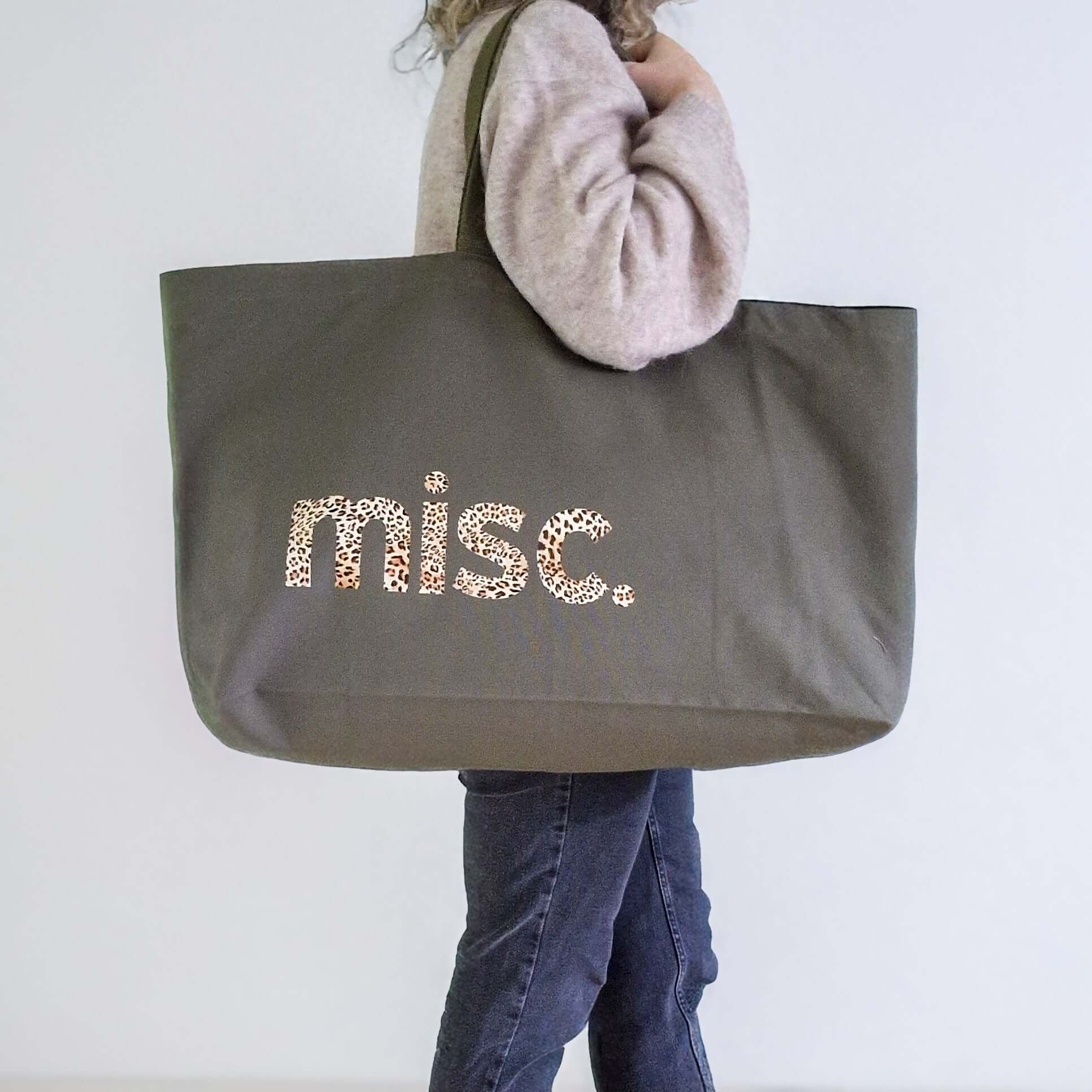 an extra large tote bag in olive colour with a leopard text - MISC.